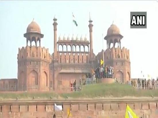 Protestors wave flags from ramparts of Red Fort in Delhi